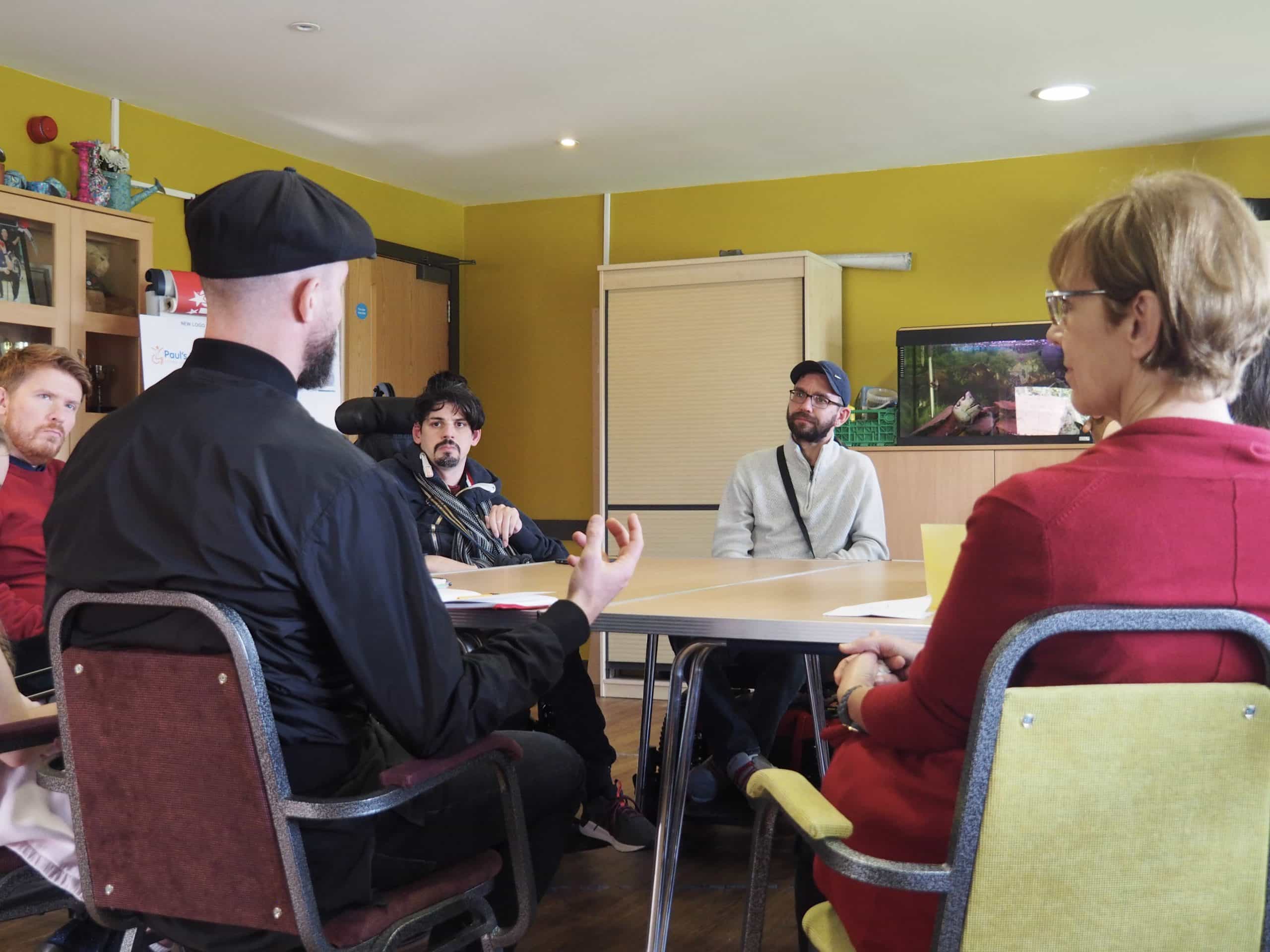 Louis sat at a table talking to members (those who use our services)