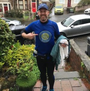 Daniel curl standing in his driveway wearing the blue Pauls Place T-shirt with the old yellow smiley face logo